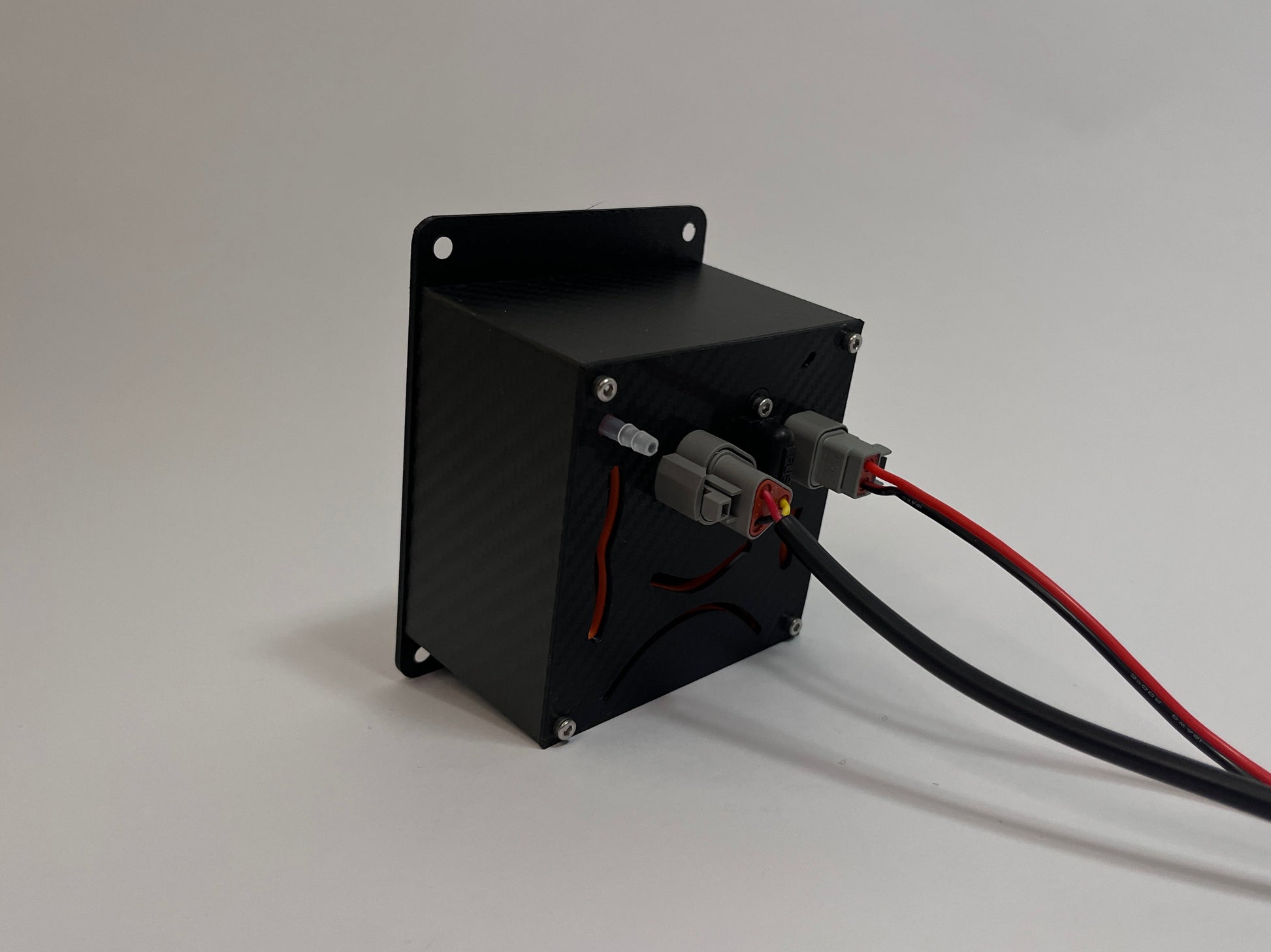 rear of motorsport hydration unit showing a black carbon fiber textured box with 2 Deutsch connectors on the rear on a white background