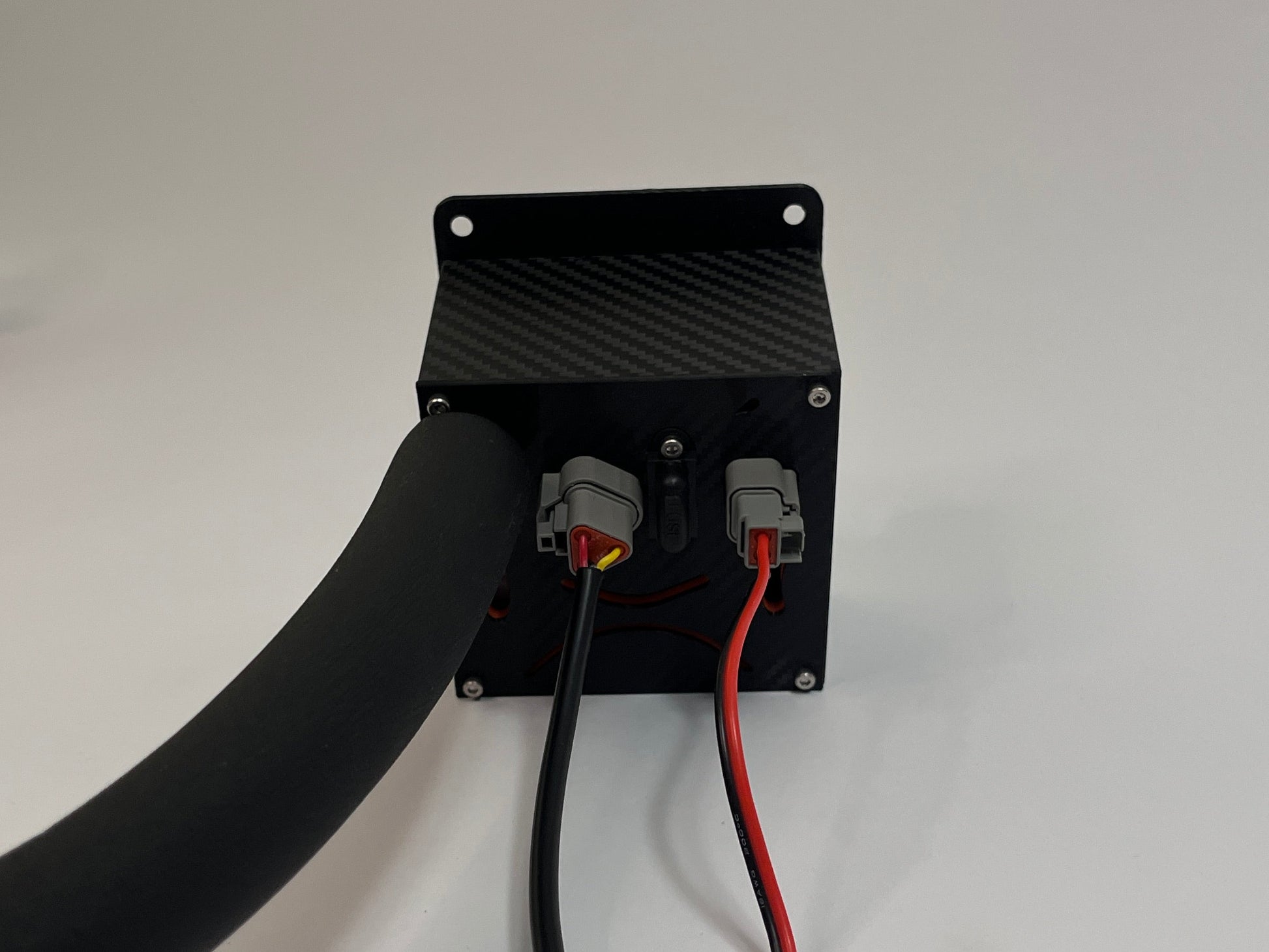 rear of racing drink unit showing a black carbon fiber unit with 2 Deutsch connectors on the rear with a black insulated tube on a white background