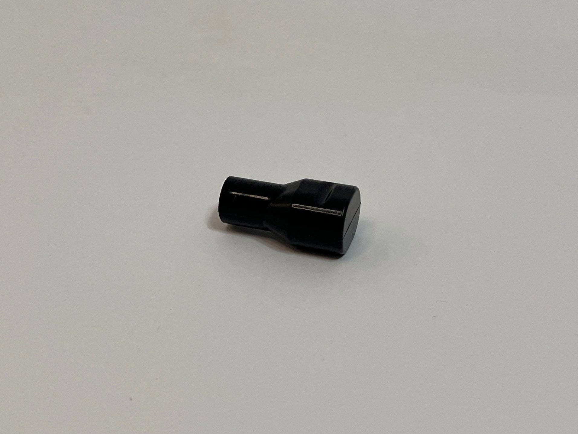 one black silicone bite valve on light gray background
