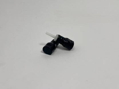 two black silicone bite valves with fittings in it, shown on a plain light gray background