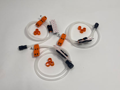 three driver side racing driver drinking kits showing per set orange dry break fitting holder, 1m silicone tubing connected to it with 3 spacers shown loosely. black silicone bite valve is connected to the tube and velcro positioners connected to the tubing on a light gray background